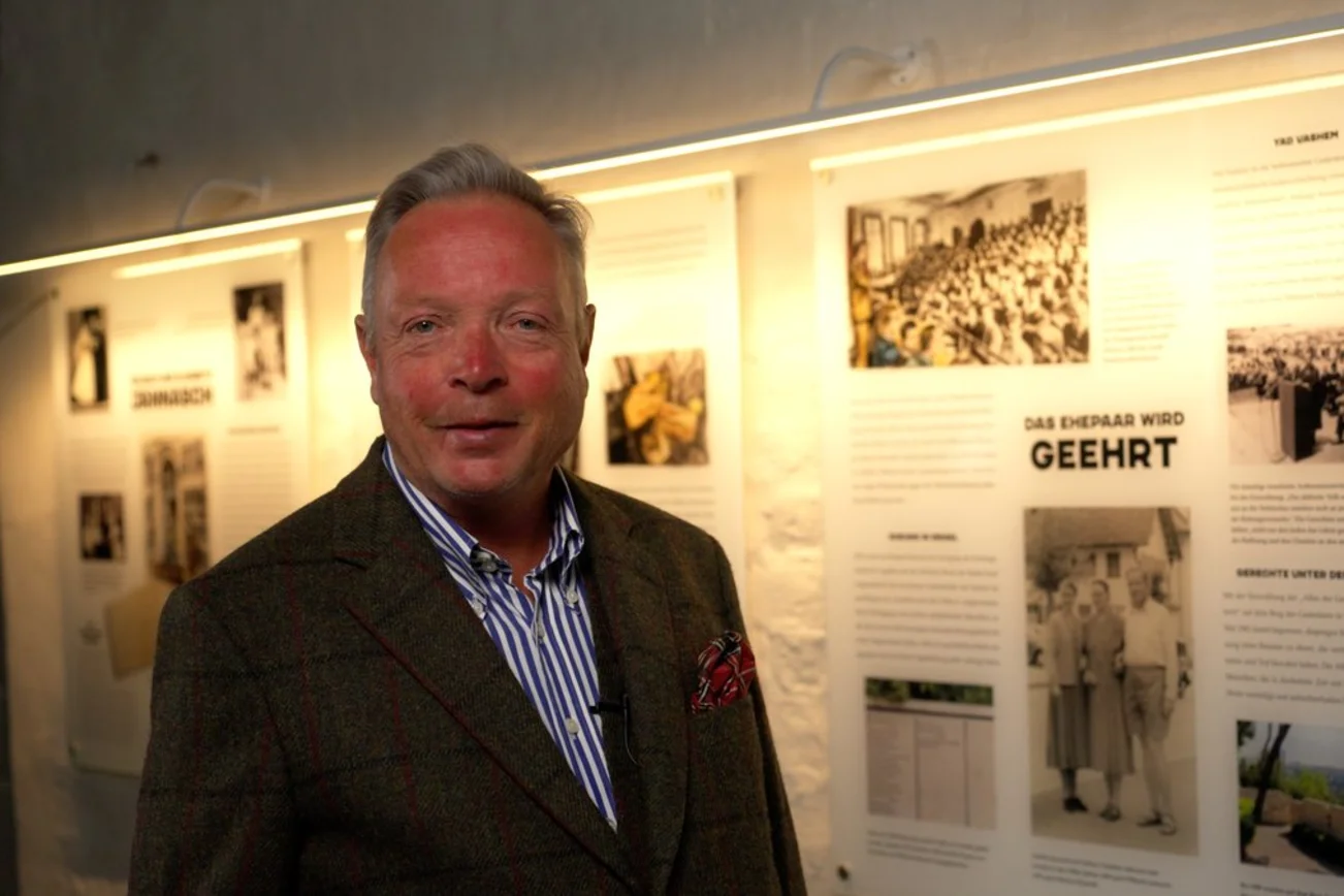 Ein Mann steht vor einer Texttafel