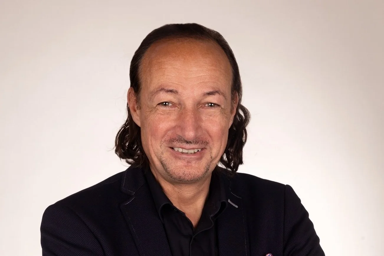 Mann guckt freundlich in die Kamera