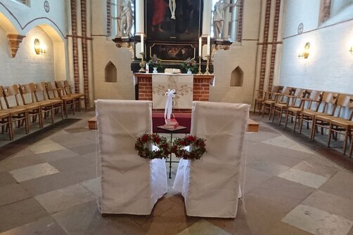 Zwei weiße Stühle vor dem Altar in der St. Johanniskirche