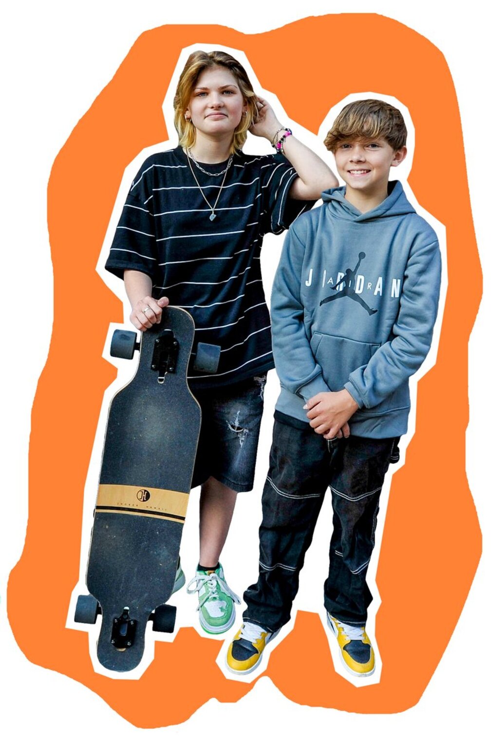 zwei Jugendliche stehen nebeneinander, das Mädchen links hält ein Skateboard vor sich angelehnt