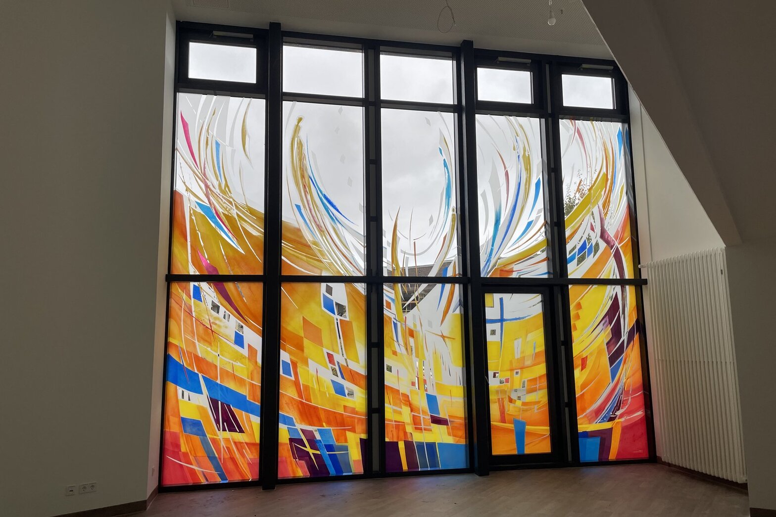 Blick auf die kunstvoll gestaltete Glasfront aus dem Raum der Stille.