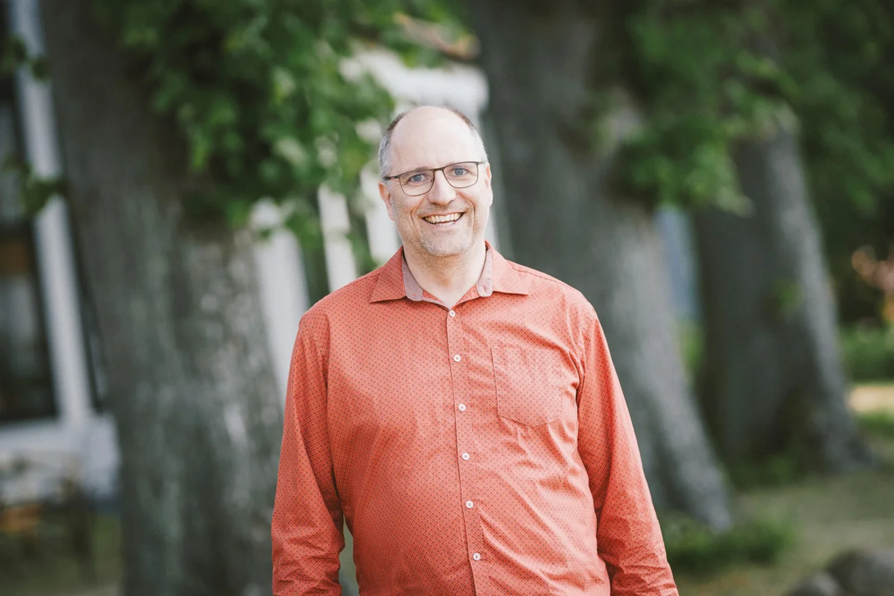 Ein Mann lächelt in die Kamera.