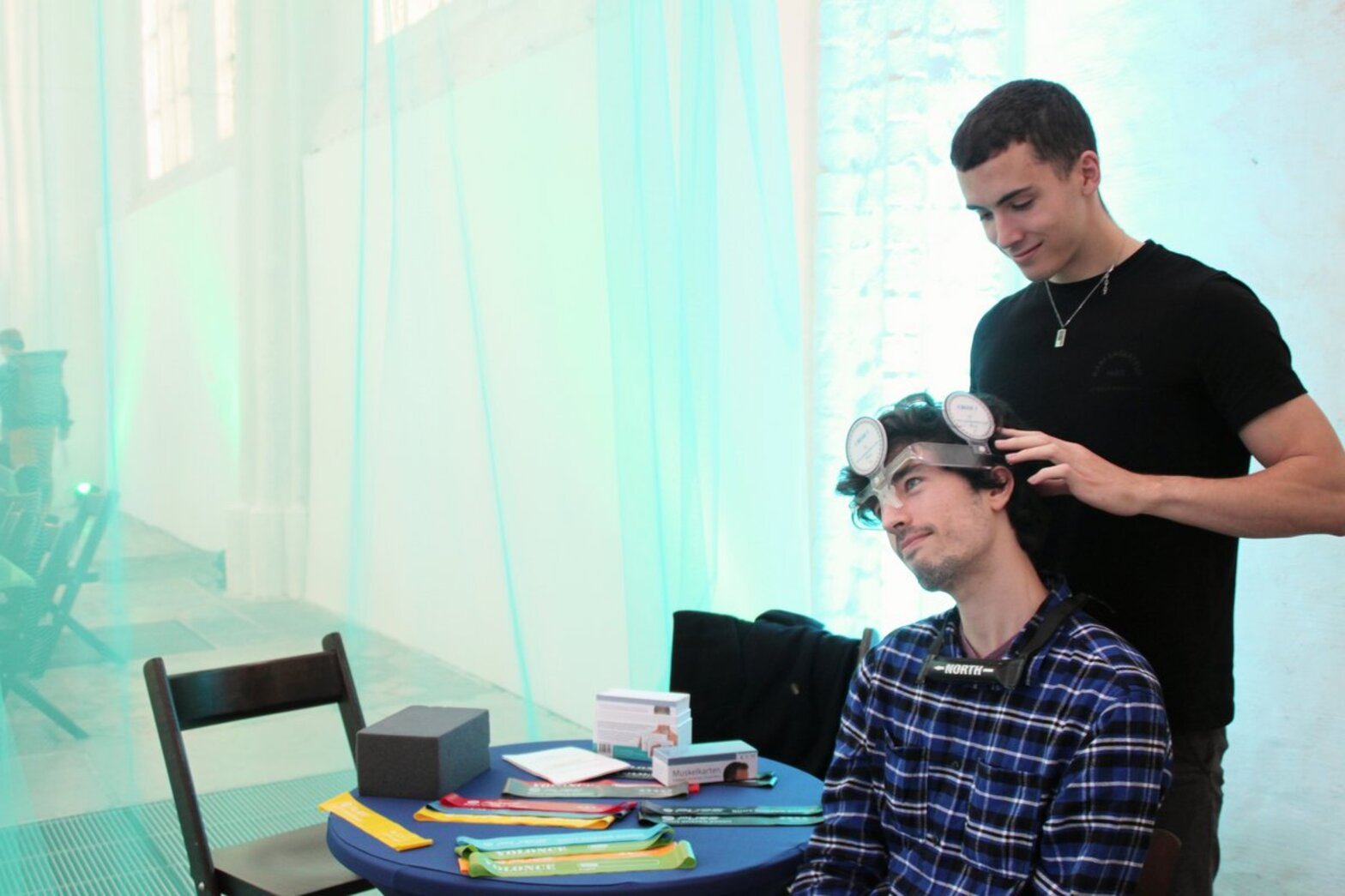 Ein Mann setzt einem anderen Mann eine Art Helm auf den Kopf.