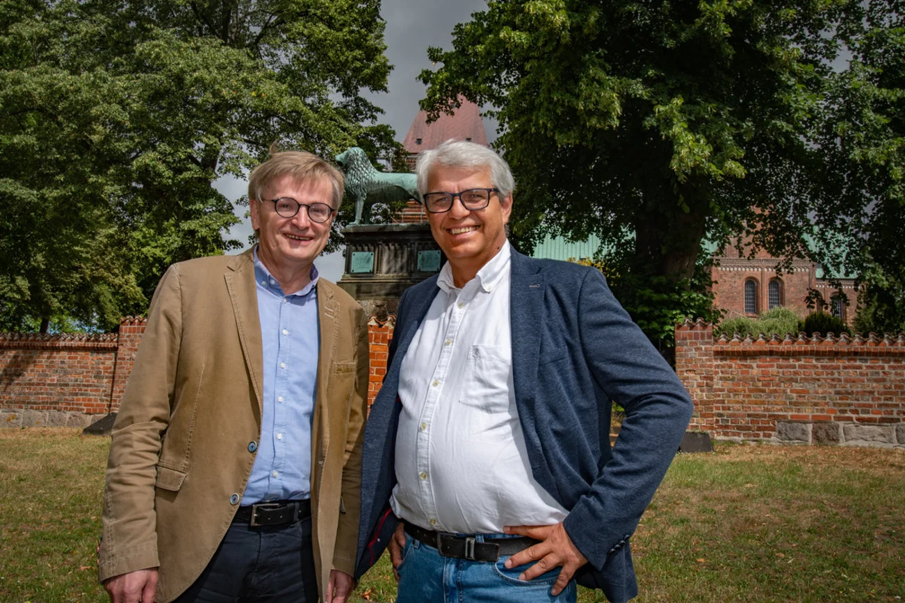 Zwei Männer stehen vor einer Kirche