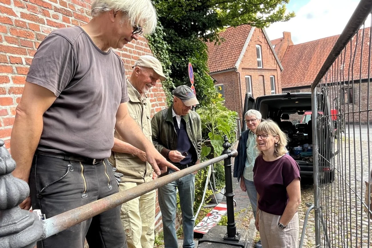 Vertreter der Gemeinde, Spender und Metallrestaurator am historischen Treppengeländer