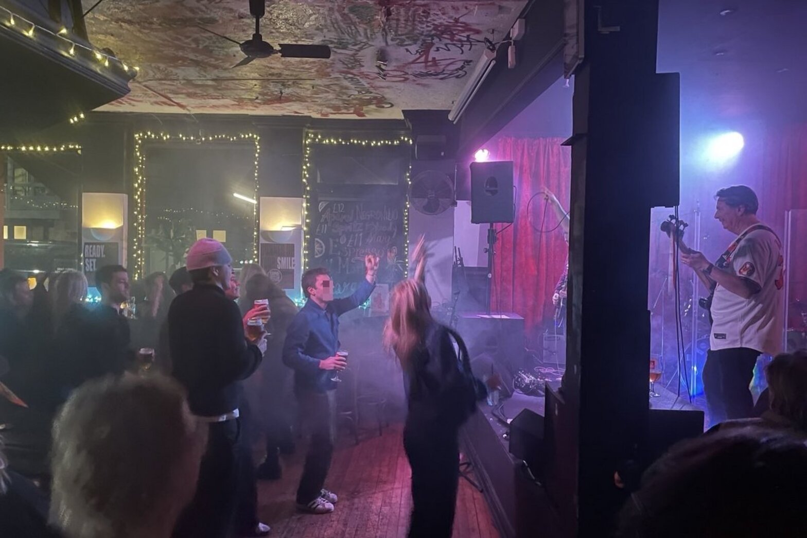 Menschen in einem Pub, die vor einer Bühne tanzen