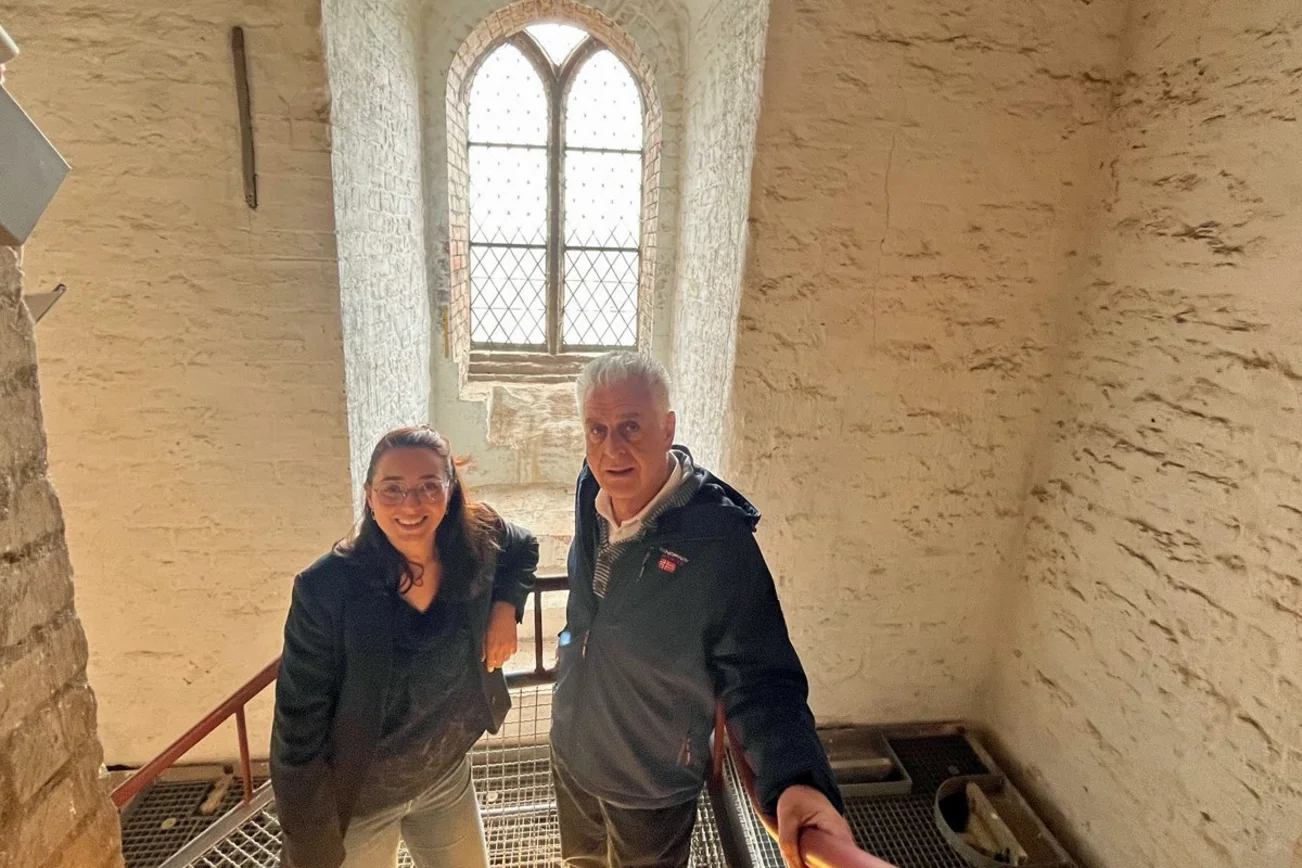 Eine Frau und ein Mann stehen im Treppenhaus einer Kirche