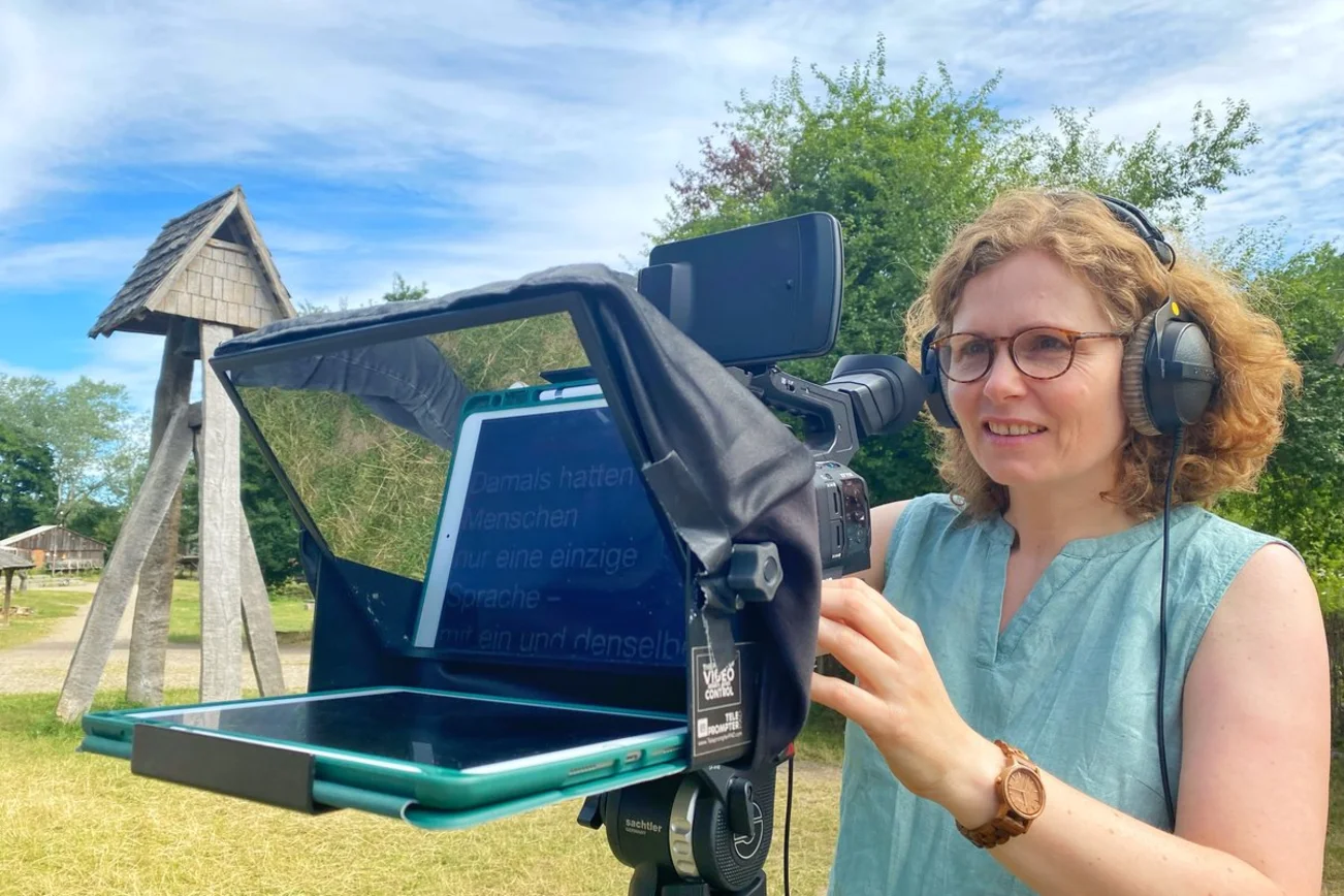 Eine Frau steht an einer Filmkamera