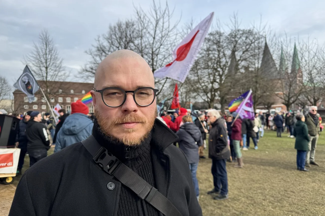Menschen demonstrieren in Lübeck - ein Mann blickt in die Kamera