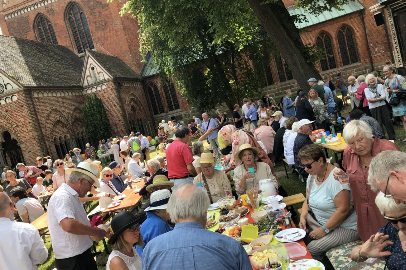 Blick auf Menschen vor einer Kirche