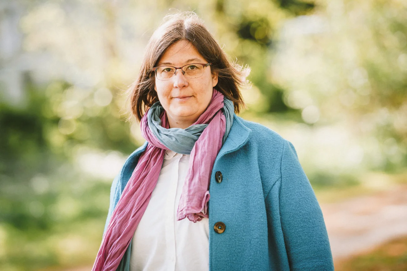 Frau guckt freundlich in die Kamera.