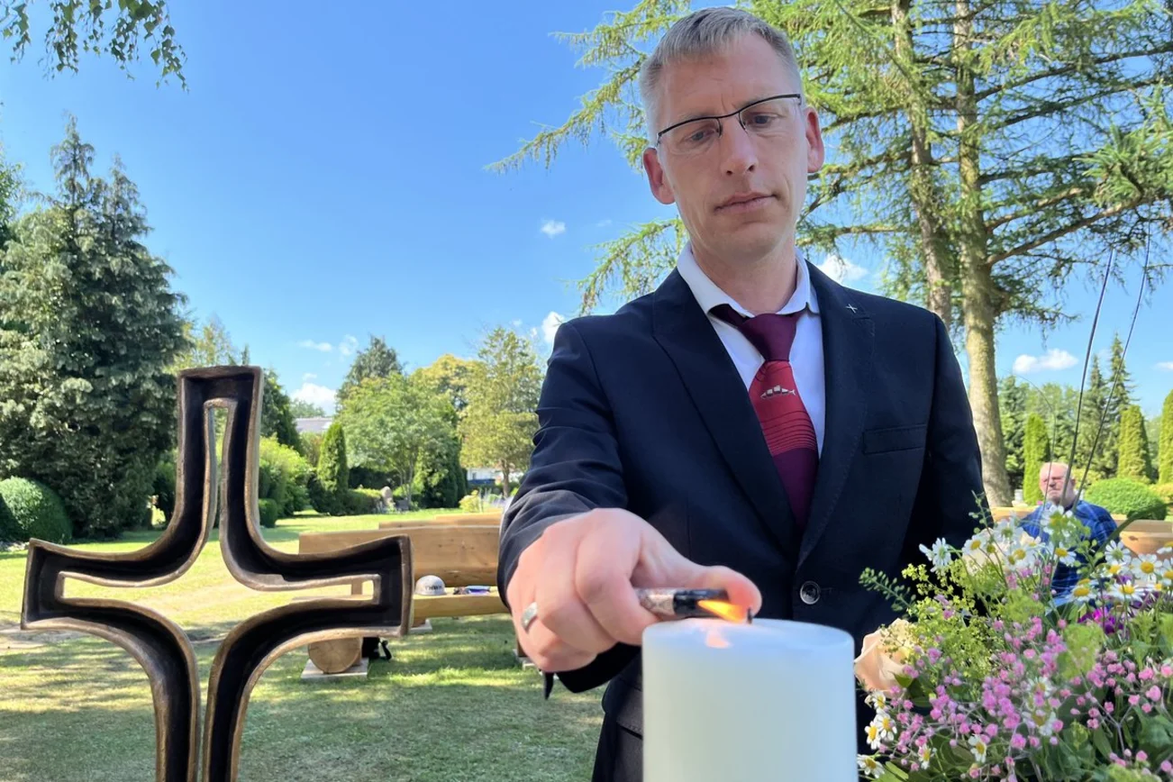 Ein Mann entzündet eine Kerze.