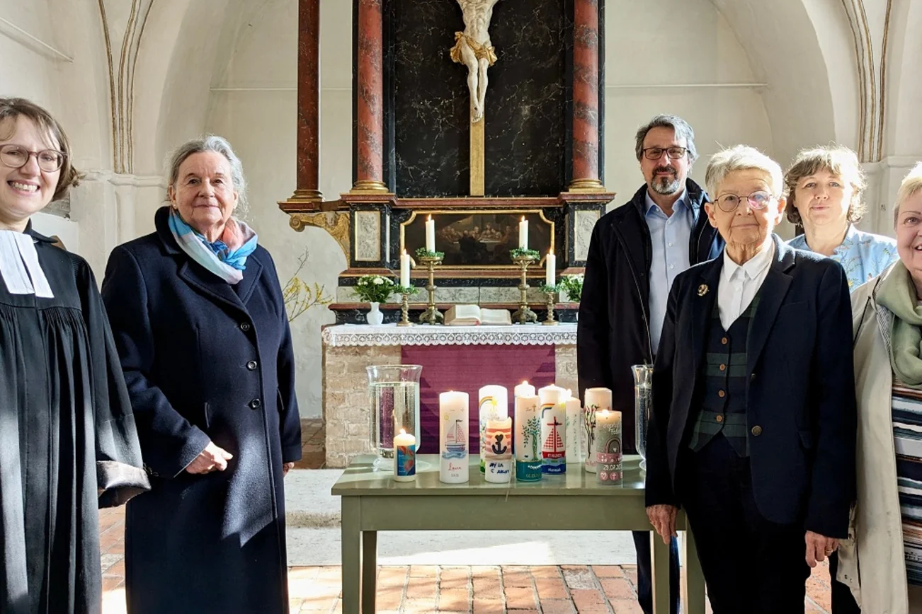 Gruppe von Menschen in einer Kirche, Kerzen auf Tisch, Altar 