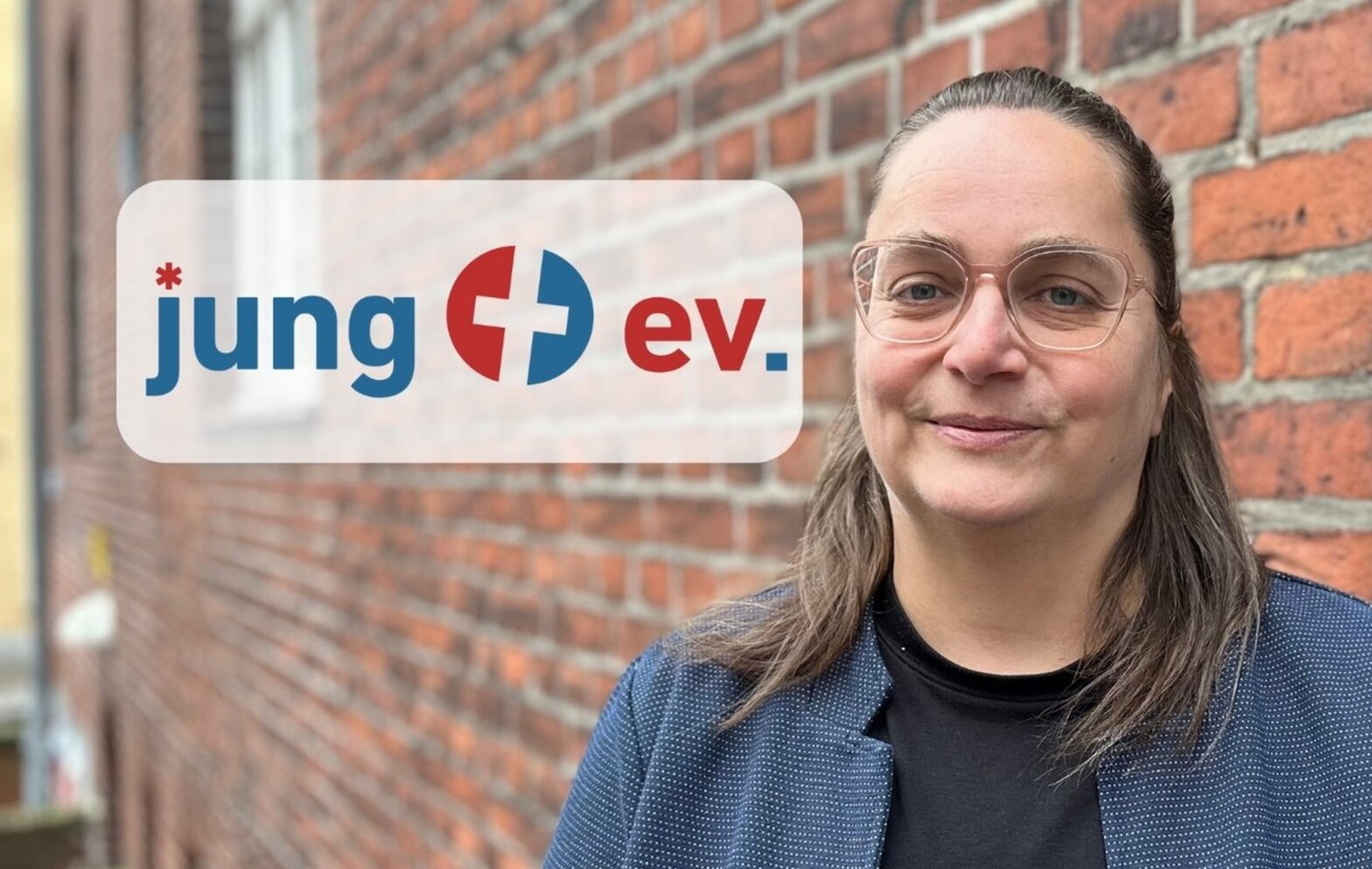 Eine Frau schaut in die Kamera. neben ihr befindet sich ein Logo. 