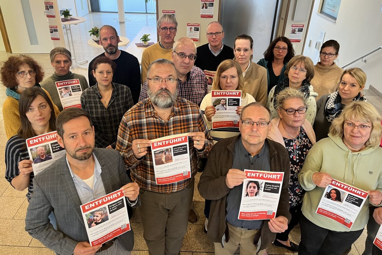 Menschenstehen in einem Raum und zeigen Plakate