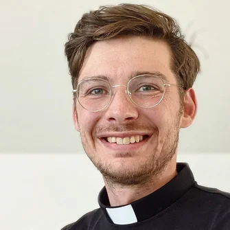 Pastor Jaan Thiesen lächelt in die Kamera - Hintergrund beige