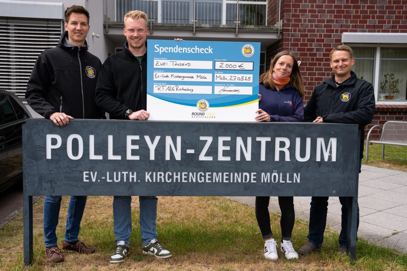 Vier Menschen mit einem überdimensionalen Scheck.