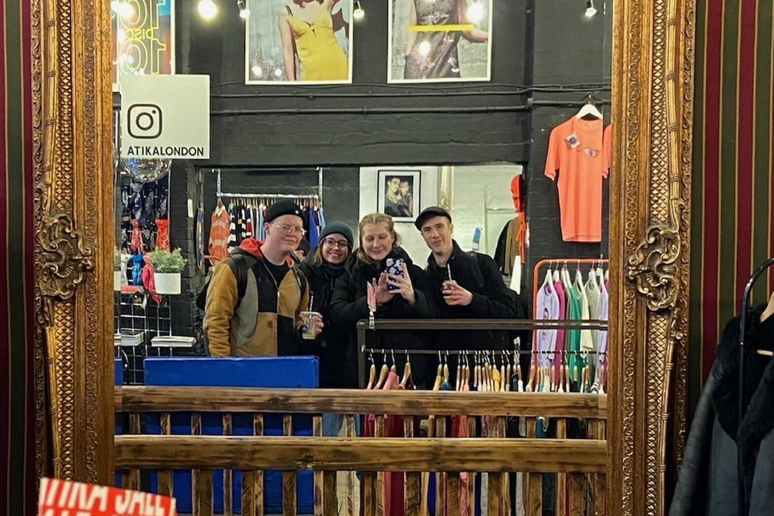 Vier junge Menschen machen ein Selfie in einem Spiegel.