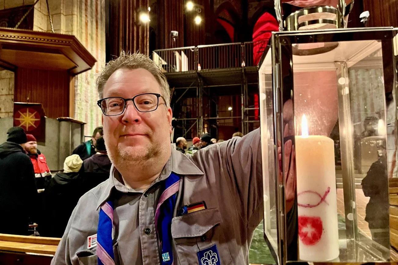 Ein Mann hält eine Laterne mit einer Kerze