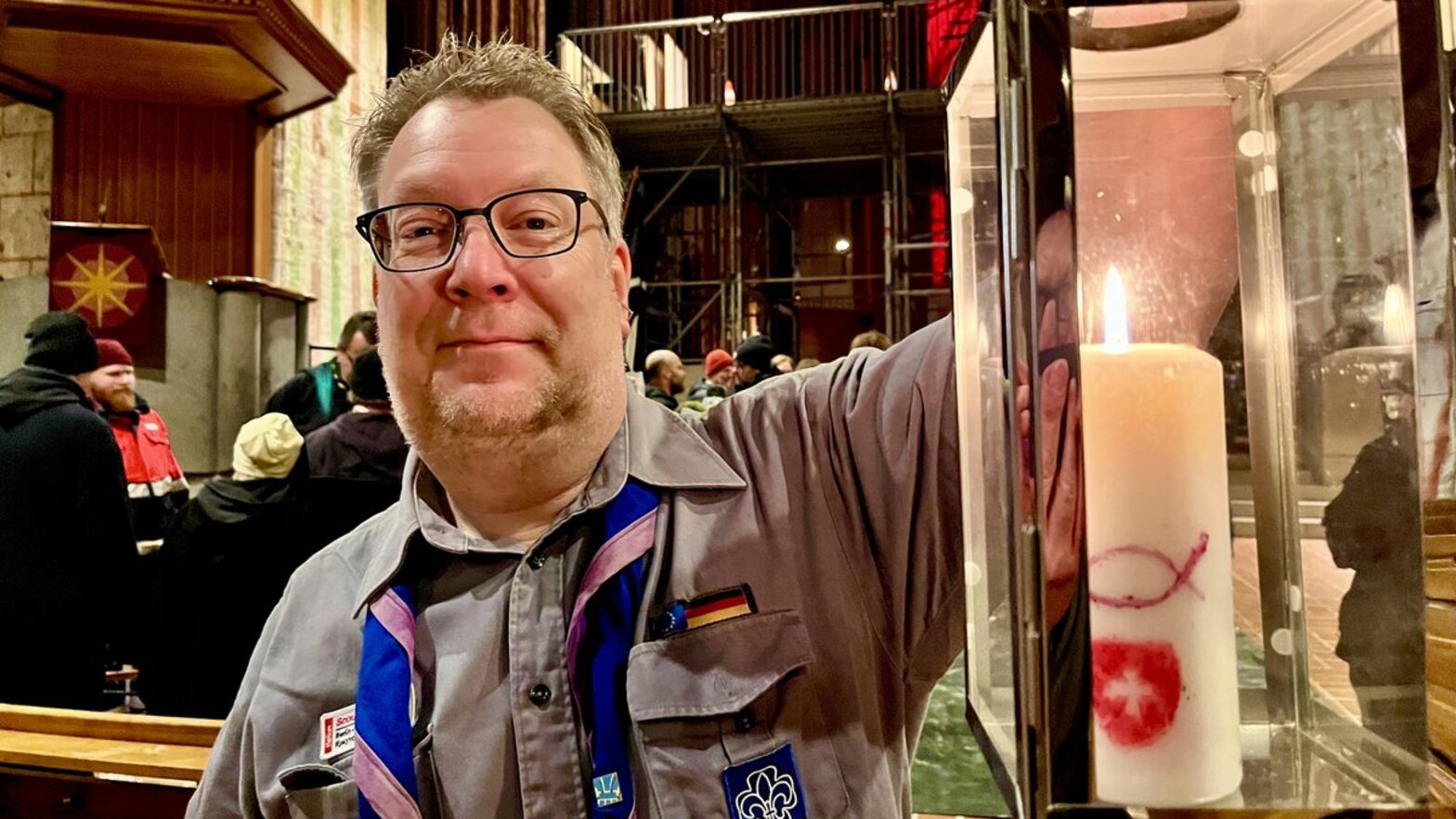 Ein Mann hält eine Laterne mit einer Kerze