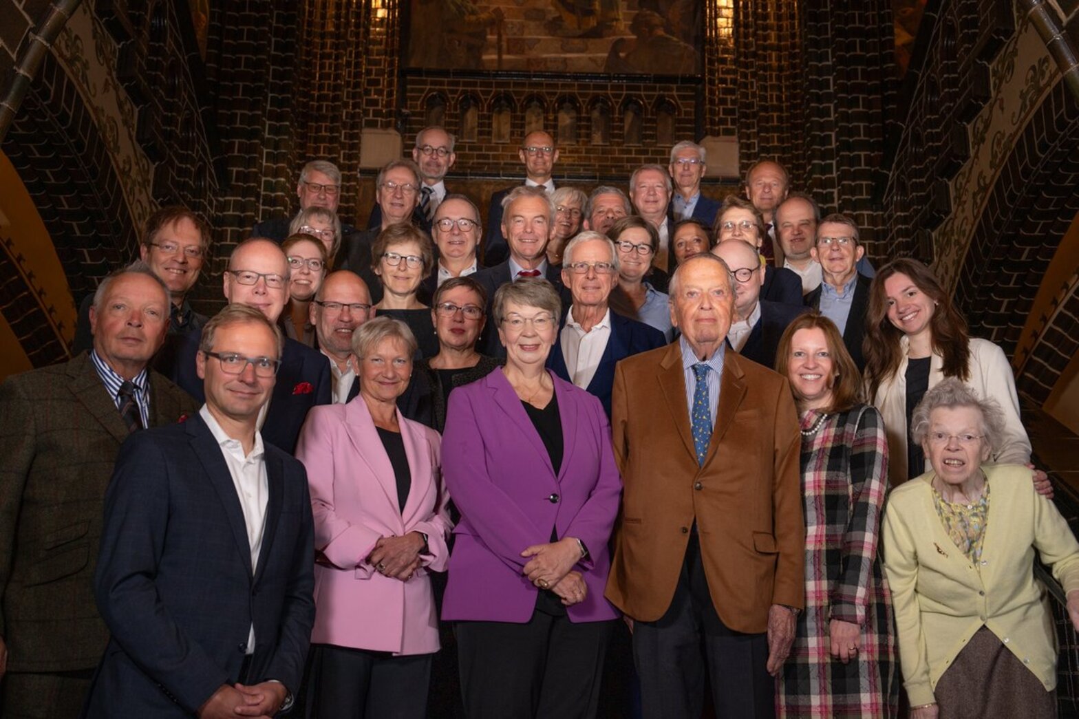 Eine größere Anzahl von Menschen steht hintereinander und nebeneinander auf einer Treppe