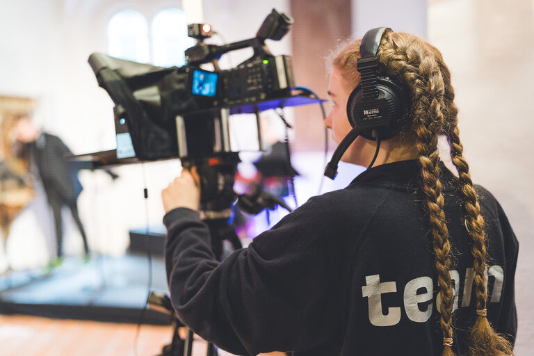 Kamerafrau hinter Kamera beim Live-Gottesdienst