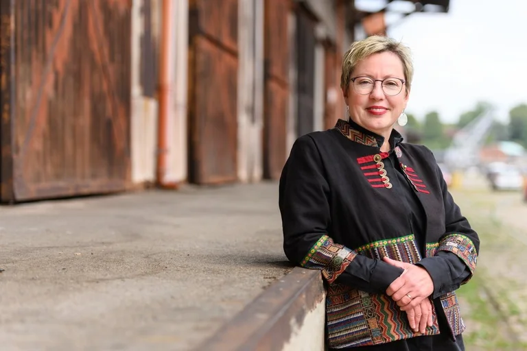 Frau lehnt sich entspannt an eine Kante