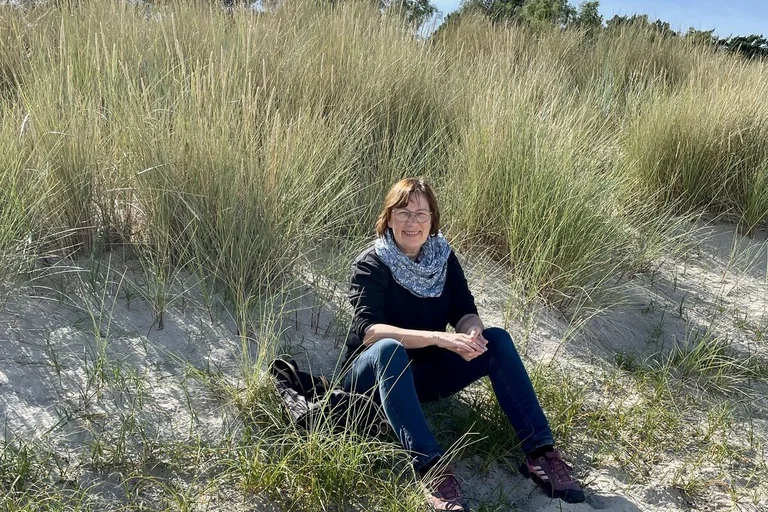 Eine Frau sitzt in einer Düne