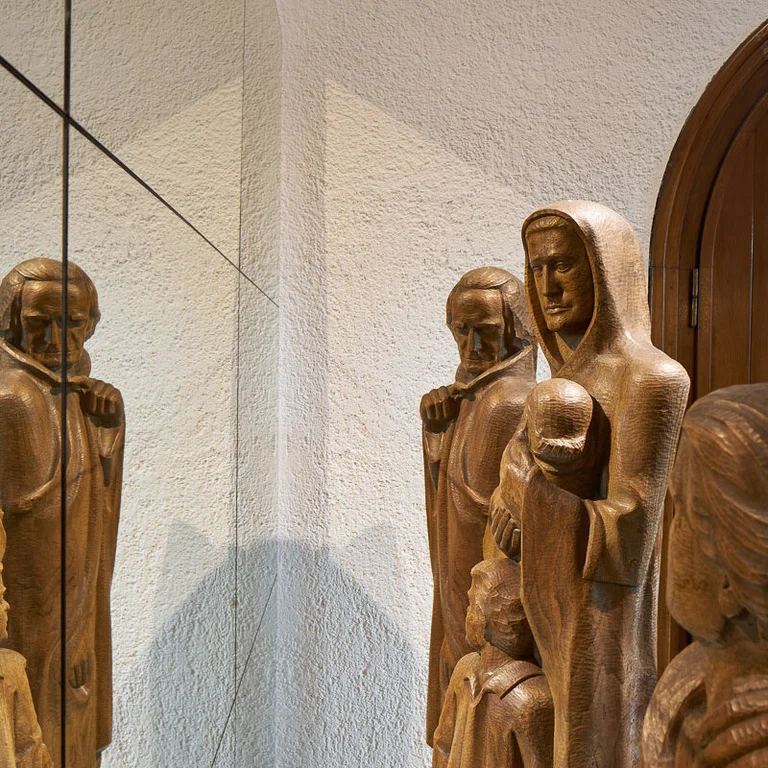 Eine Installation aus Holzfiguren vor einem Spiegel in der Lutherkirche