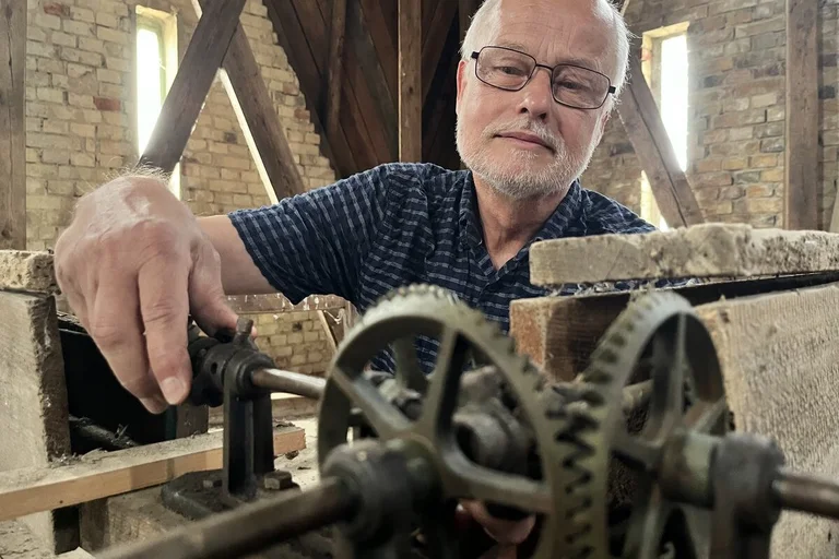 Ein Mann arbeitet an einer Uhr. 