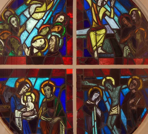 Ansicht eines viergeteilten Rundfensters mit gemalten Szenen in der Martin-Luther-Kirche Wentorf