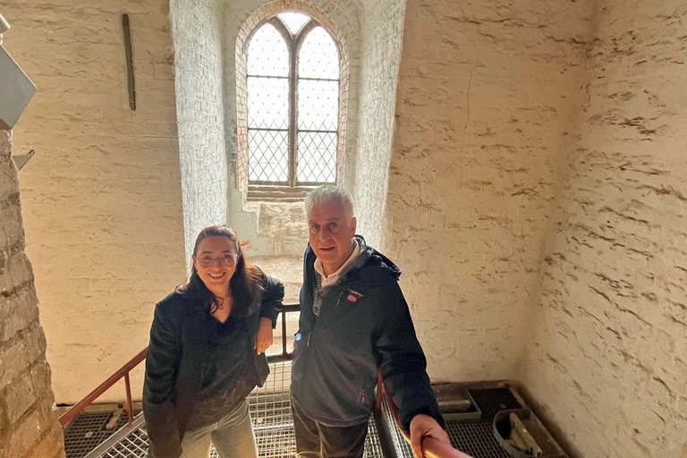 Eine Frau und ein Mann stehen im Treppenhaus einer Kirche