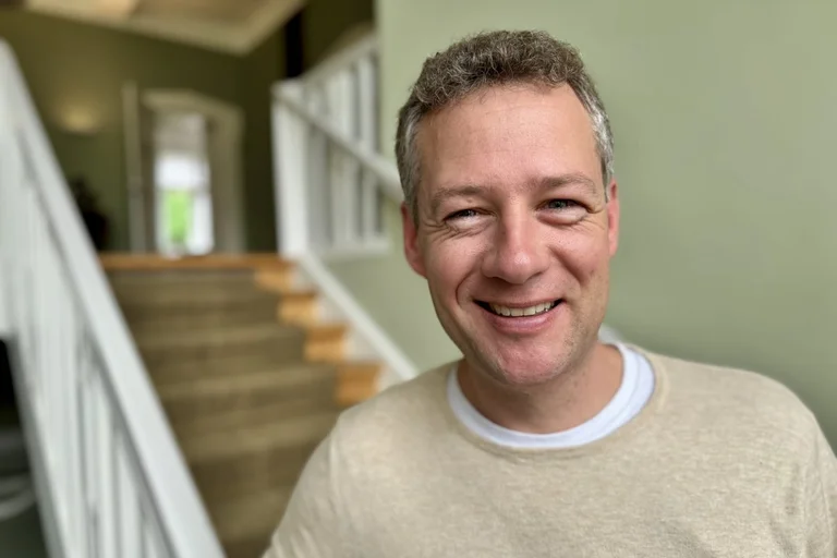 Ein Mann lächelt in die Kamera