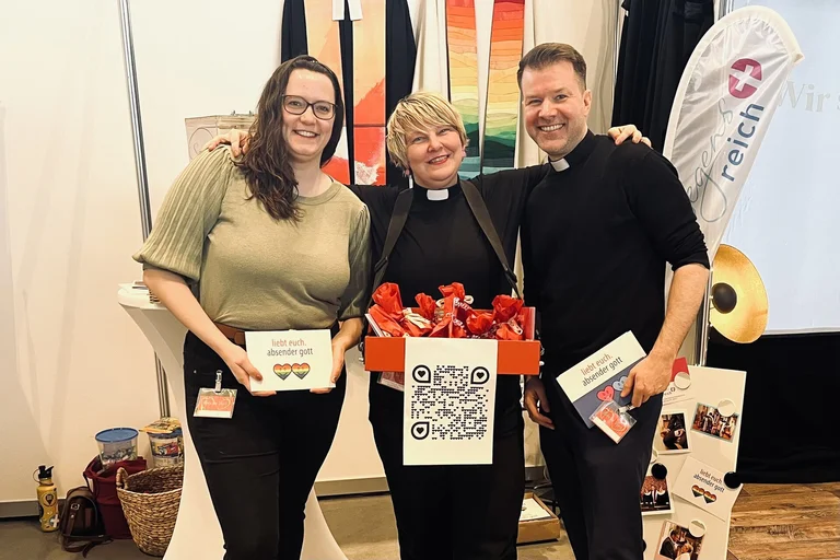 Drei Menschen lächeln in die Kamera.