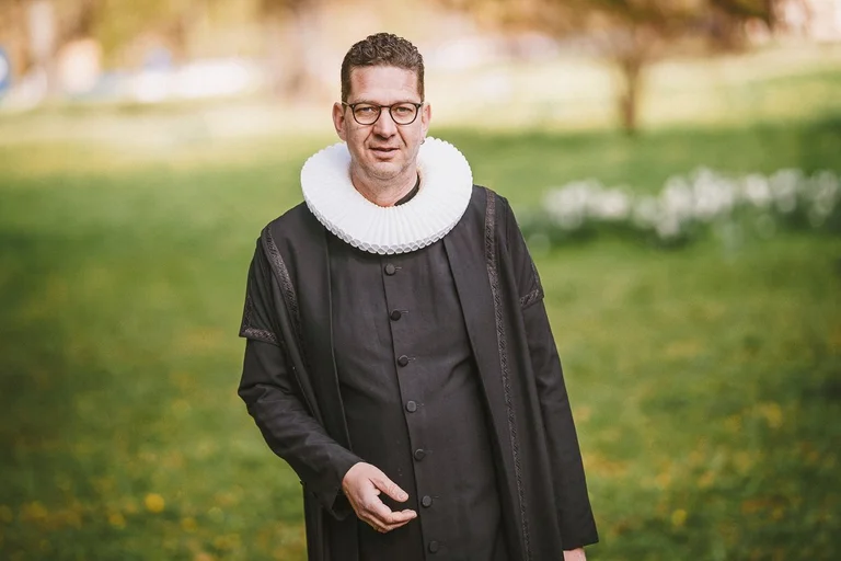 Ein Mann steht auf einer Wiese.