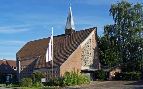 Kapelle über Eck in Abendsonne, links Fahrrad am Schaukasten, in Mitte Kreuz-Hochfahne, rechts Birke mit Schatten