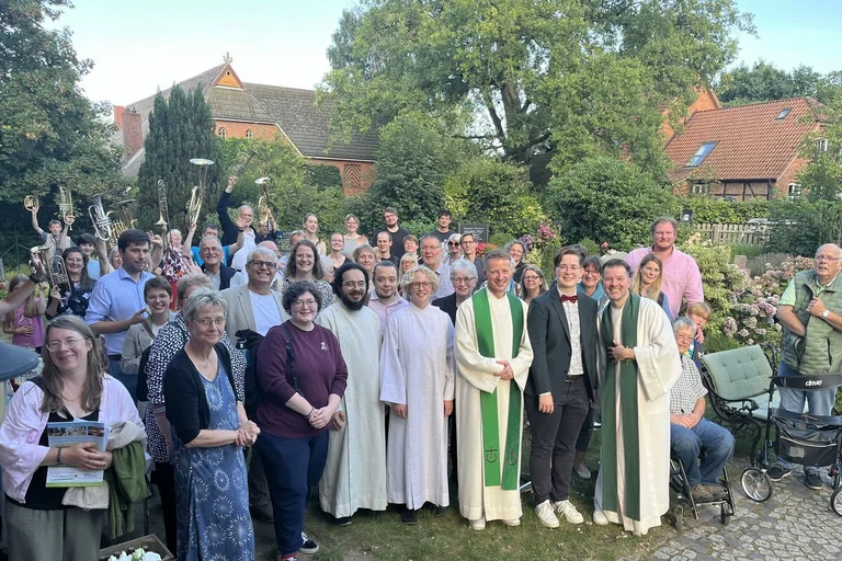 Gruppenfoto im Freien mit Pastoren, Musikern und Gottesdienstbesuchenden