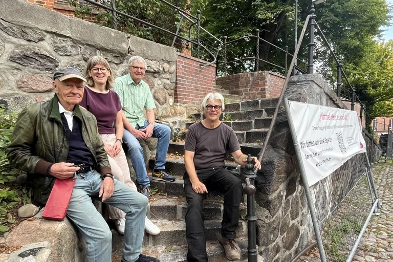 Großspender Hans Jürgen Ohff, Pastorin Hilke Lage, Gerhard Motten vom Kirchengemeinderat und Restaurator Peter Eingrüber am historischen Treppengeländer an der Möllner St.-Nicolai-Kirche.