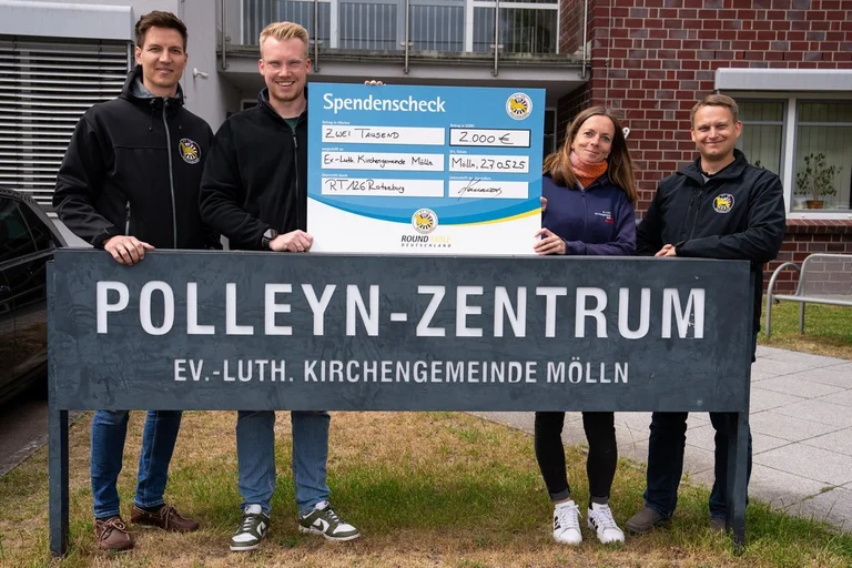 Vier Menschen mit einem überdimensionalen Scheck.