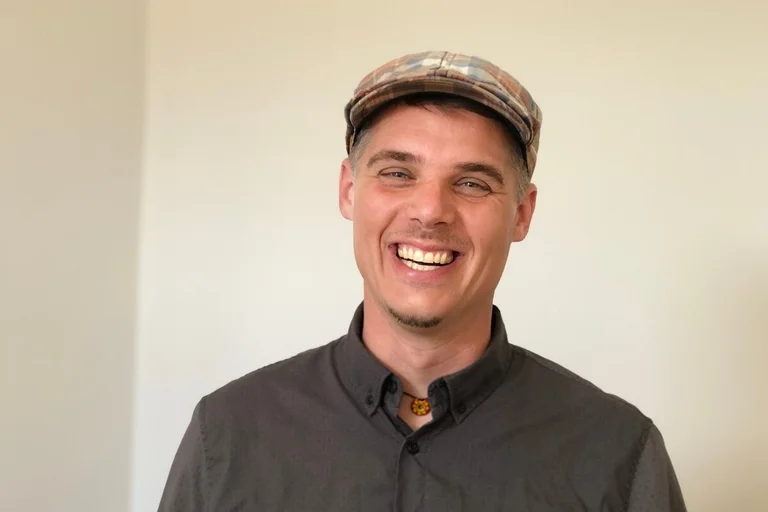 Mann, der den Betrachtenden anlächelt