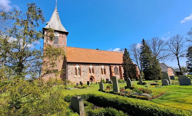 Außenansicht der Marienkirche Büchen-Dorf mit blauem Himmel und  grüner Rasenfläche vor der Kirche