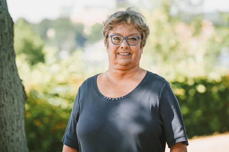 Frau lächelt im Freien in die Kamera