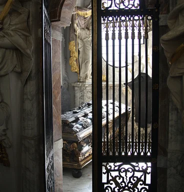 Blick durch eine Gittertür in eine Grabkapelle mit Sarkophag