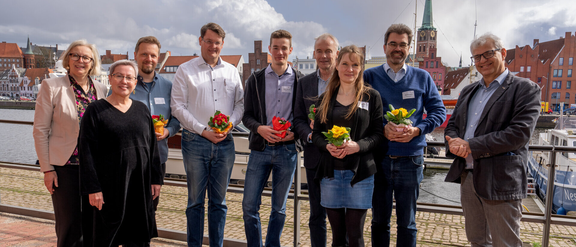 Menschen vor einer maritimen Kulisse. 